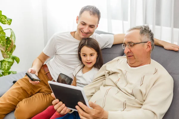 Щаслива сім'я використовує планшетний комп'ютер у вітальні — стокове фото