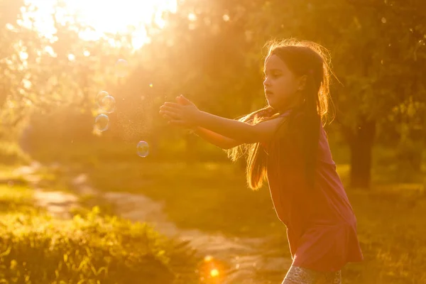 Cute little girl is blowing a soap bubbles — Stock Photo, Image