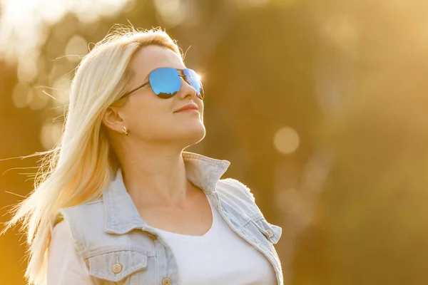 Retrato de uma jovem mulher, loira, óculos de sol, ao ar livre no parque. — Fotografia de Stock