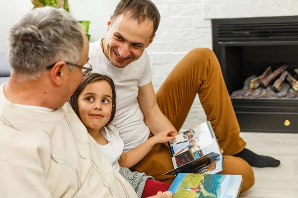 Lachende familie met grootouders fotoalbum thuis houden — Stockfoto