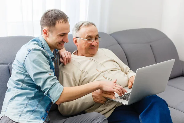Vecchio padre e figlio sono conversazione amichevole seduti a casa sul divano — Foto Stock