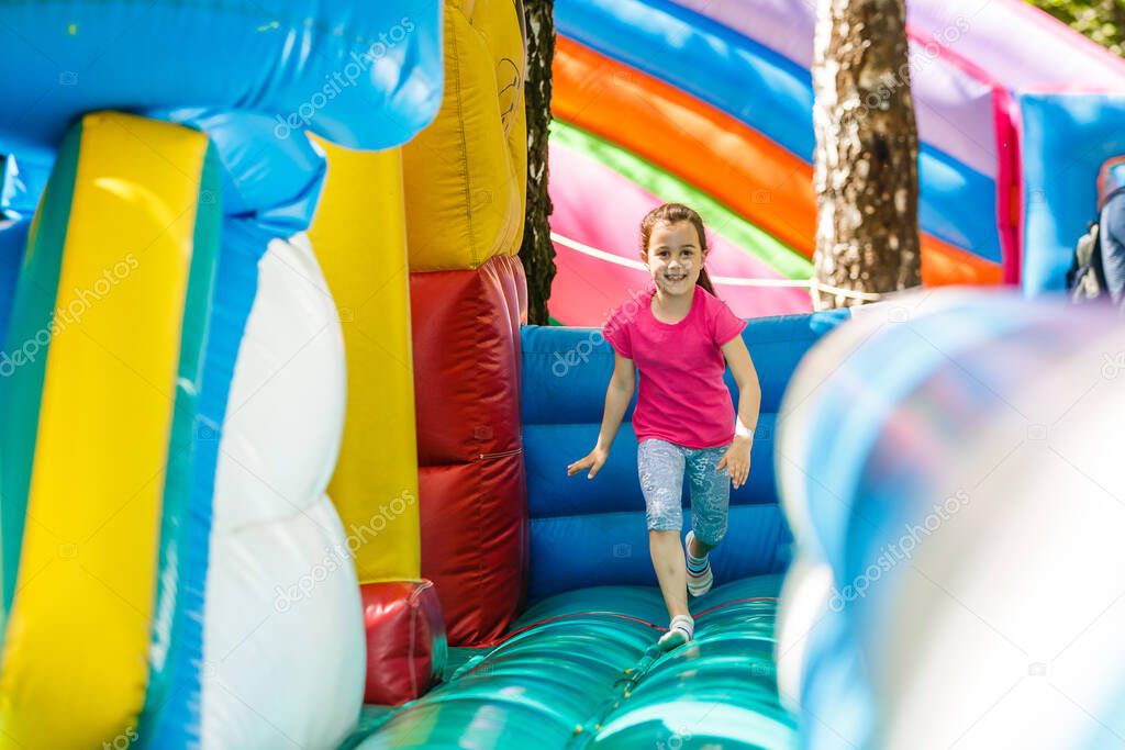 Little Girl sliding down an inflatable Slide