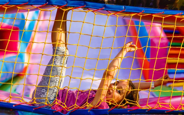 Criança a saltar ao trampolim no parque infantil. Menina criança ativa se divertindo no centro esportivo — Fotografia de Stock