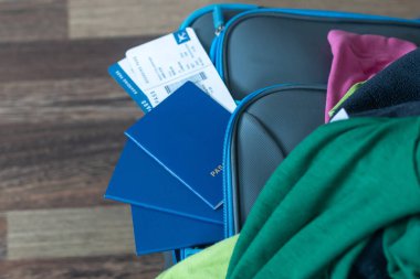 Bavul. dağınık kıyafetler, pasaport, para