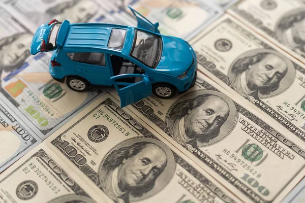 Notas de cem dólares com carro de brinquedo pequeno . — Fotografia de Stock
