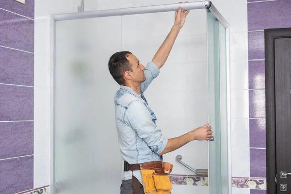 Klempner installiert Duschkabine im Badezimmer. — Stockfoto