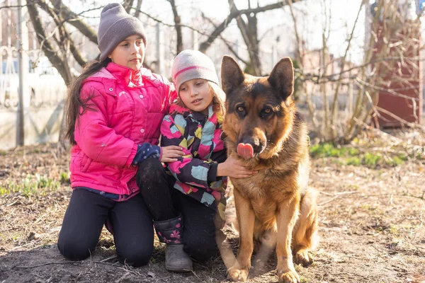 Crianças correndo com seu cachorro pastor alemão animal de estimação no parque — Fotografia de Stock