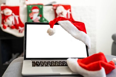 Beyaz ahşap masada boş ekran dizüstü bilgisayar. Noel dekorlu, modern, rahat bir ev oturma odası. Ofis masası çalışma alanı. Kopyalama alanı oluşturun. Kış satışları, online alışveriş.