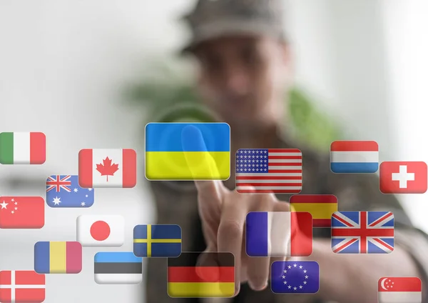 Mano empujando en una interfaz de pantalla táctil, eligiendo Ucrania. banderas del mundo —  Fotos de Stock