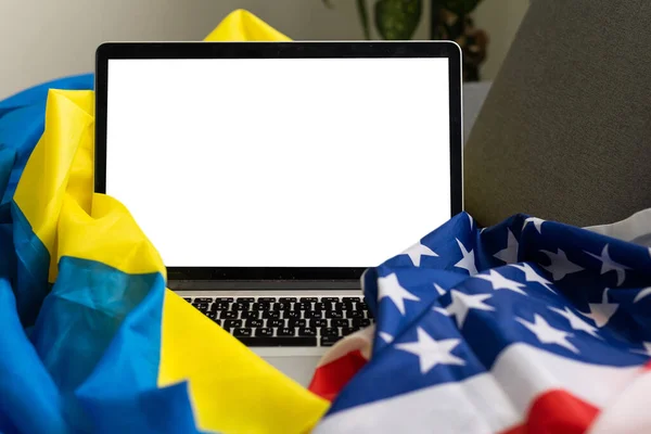 Laptop with blank screen near america and ukraine flag — стоковое фото