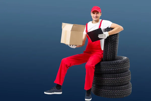 Mechanic Holding Car Tire on a white background — Stock Photo, Image