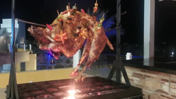 A carne frita-se em uma grelha em uma saliva. O carneiro é frito em um cuspo em uma fogueira aberta em um restaurante . — Vídeo de Stock