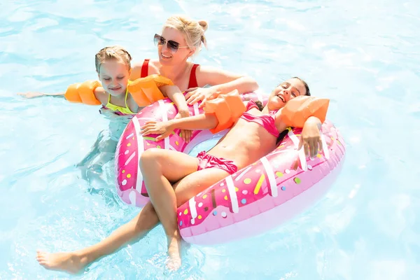 Famille heureuse dans la piscine, s'amuser dans l'eau, mère avec enfants profitant d'un parc aquatique, station balnéaire, vacances d'été, concept de vacances — Photo