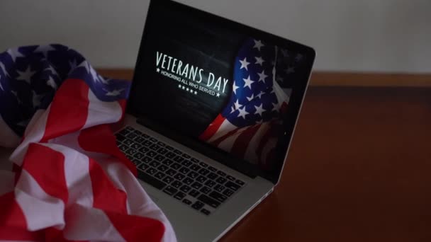 Veteranen dag geschreven in laptop met vlag van de Verenigde Staten, op een rustieke houten achtergrond — Stockvideo