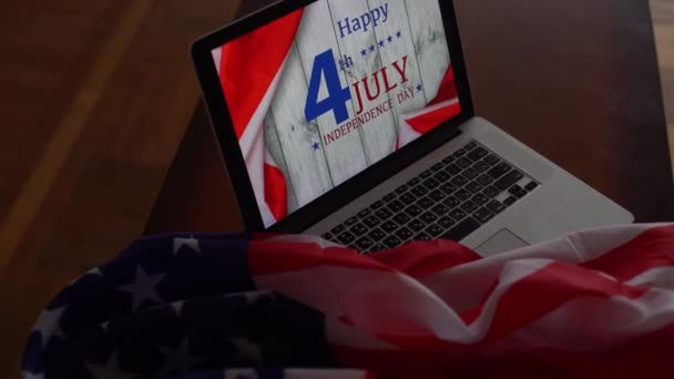 American flags with inscription Happy Independence Day on laptop — Stock Video