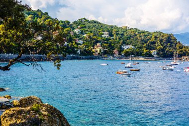Ligurya ve Akdeniz limanında denize demirlemiş balıkçı tekneleri Ulusal Park Cinque Terre Sahili kıyısındaki Riviera di Levante kıyısında mavi gökyüzü, Riomaggiore köyü, Liguria, İtalya.
