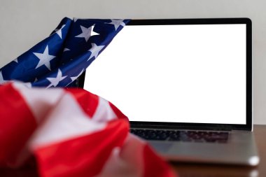 Boş ekranlı dizüstü bilgisayar ve ofiste ABD bayrağı