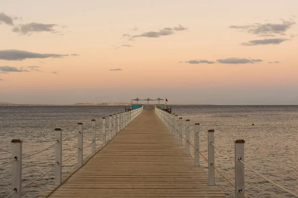 Drewniany ponton na morzu, złoty zachód słońca. — Zdjęcie stockowe