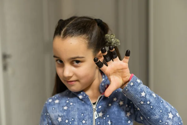 Menina bonito mostrando sua palma pintada de preto — Fotografia de Stock