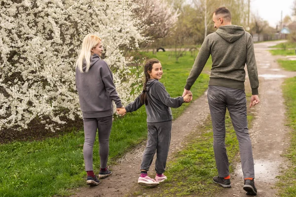 Familia divirtiéndose con el árbol floreciente en el floreciente jardín de primavera — Foto de Stock