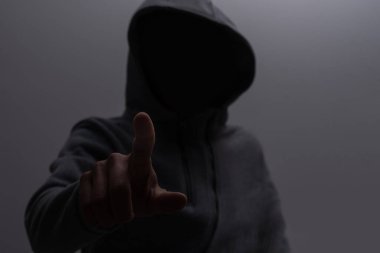 Siyah arka planda koyu kapüşonlu cesur bir adamın portresini yakından çek. Sırların gizliliği kavramı ve hükümetten saklanan insanlar. Hackerlar ve hırsızlar. Alçak tuş.