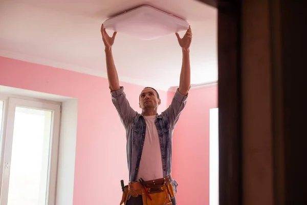 Reparador o electricista profesional en ropa de trabajo instalando puntos de luz —  Fotos de Stock