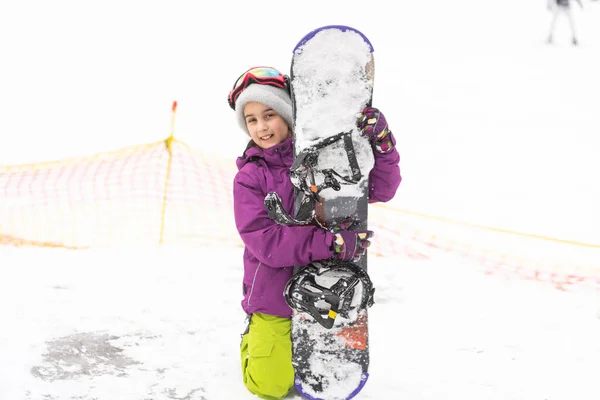 小さなかわいい女の子は子供のスノーボード、子供のための冬のスポーツ、アクティブなスポーツの安全性を学ぶ. — ストック写真