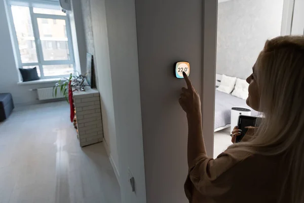 家で美しい幸せな女プッシュ ボタン デジタル サーモスタット — ストック写真
