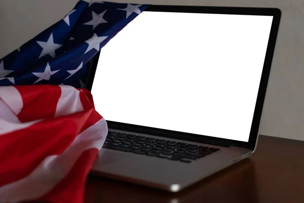 Ordinateur portable avec écran blanc et drapeau des États-Unis sur le bureau — Photo
