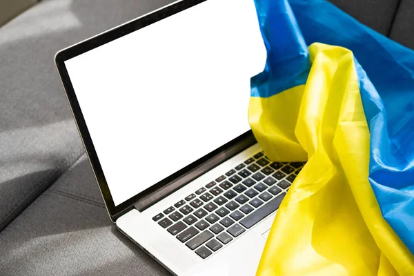 Laptop makieta na ukraińskim tle żółto-niebieskiej flagi. — Zdjęcie stockowe