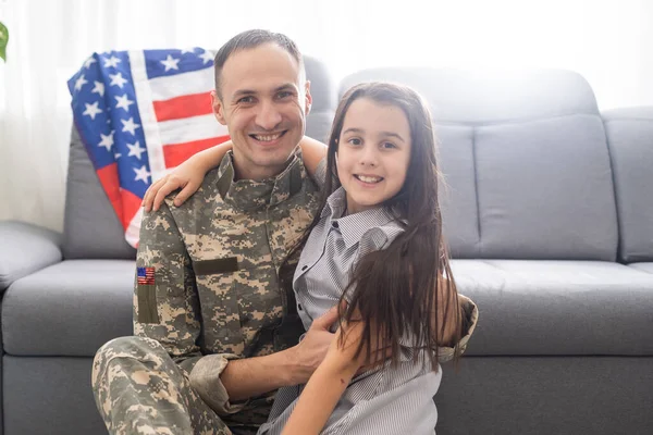 Little child is very happy her father came back from army. Little kid is hugging her father. — Stock Photo, Image