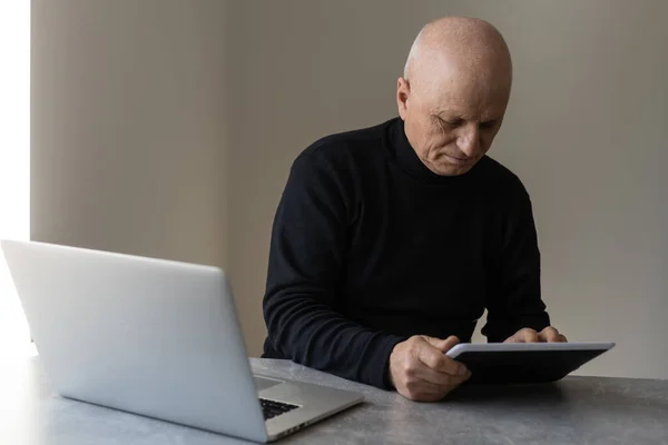 Uomo anziano preoccupato utilizzando il computer portatile a casa — Foto Stock