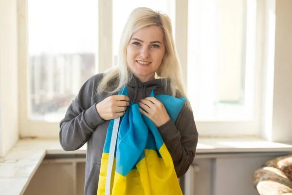 Flüchtlingsfrau mit ukrainischer Flagge — Stockfoto