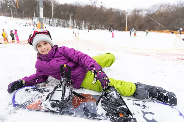 Snowboard Winter Sport. Niña jugando con nieve usando ropa abrigada de invierno. Fondo de invierno —  Fotos de Stock