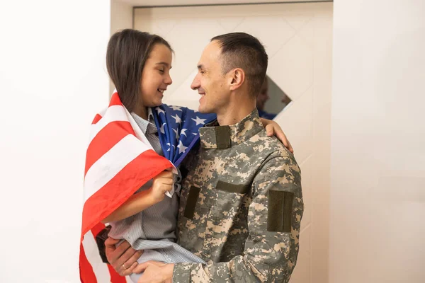 Pikkulapsi on iloinen, että hänen isänsä palasi armeijasta. Pikkupoika halaa isäänsä. . — kuvapankkivalokuva