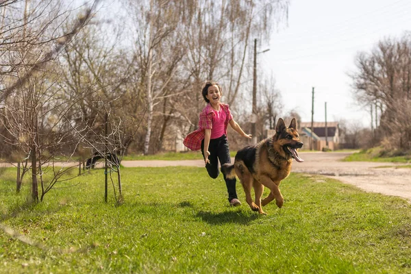 Το κοριτσάκι τρέχει γρήγορα με ένα βοσκό στο πάρκο. — Φωτογραφία Αρχείου