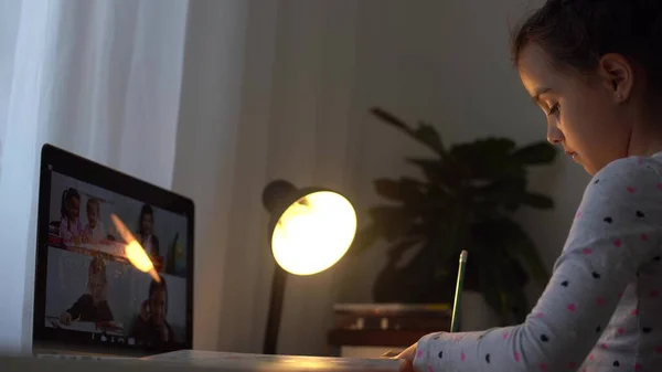 Mooi basisschoolmeisje afstandsonderwijs thuis. Gericht schattig kind luisteren audio les studeren aan tafel, huiswerk maken. Kinderen onderwijs op afstand over quarantaine concept. — Stockfoto