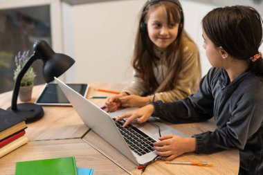 İki kız kardeş evlerinin oturma odasında video görüşmesi yapıyor.