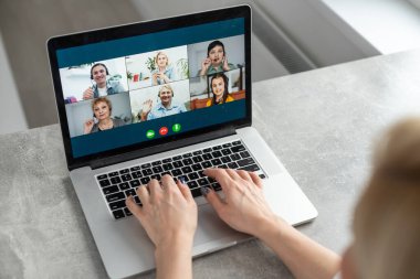 Serbest çalışan, uzaktan çalışan, kazançlı bir konsept. Genç, gülümseyen, güzel bir kadın çalışan bilgisayar ekranına bakıyor. İnternetteki konuşma sırasında. Uzak öğrenme, bağlantı