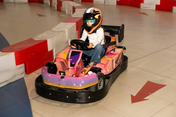 Chica feliz conduciendo un coche de juguete. Parque de atracciones para niños —  Fotos de Stock