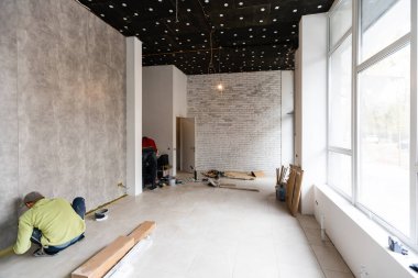 Alışveriş penceresi olan yenilenmiş bir oda. Ahşap zemin ve beyaz duvarları olan boş bir mağaza.