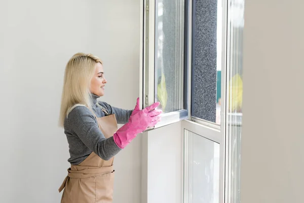 Mujer joven ventana de limpieza en casa después de la renovación —  Fotos de Stock