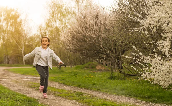 Счастливая маленькая девочка играет в весеннем вишневом саду . — стоковое фото