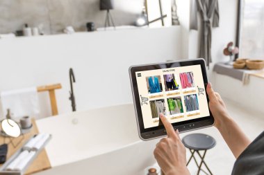 İnternetten alışveriş yapmak için dijital tablet kullanan kadın