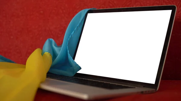 Ukrayna sarı-mavi bayrak arkaplanındaki laptopun modeli. — Stok fotoğraf