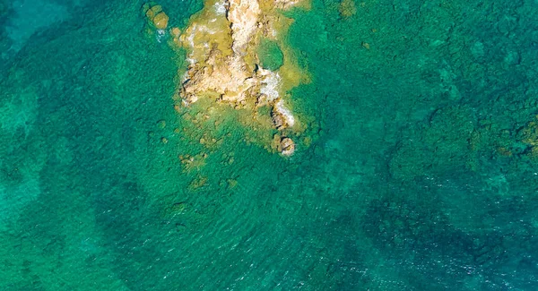 ターコイズブルーの海水でビーチの岩を打つ海の波の空中トップビュー。ポルトガルの海岸線の素晴らしい岩の崖の海景。ドローンショット. — ストック写真
