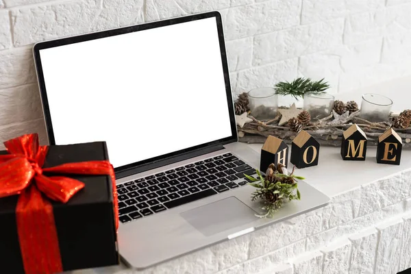 Laptop met blanco scherm op een bureaublad thuis, kerstcadeaus en decoraties op de achtergrond — Stockfoto