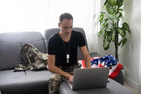 미국 국기 근처에서 노트북을 보고 있는 애국 군인 — 스톡 사진