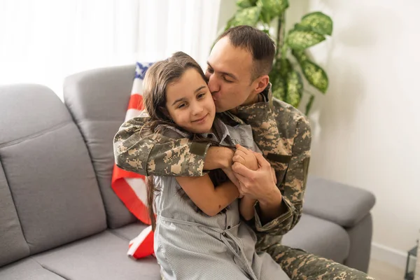A criancinha está muito feliz por o pai dela ter voltado do exército. O miúdo está a abraçar o pai. . — Fotografia de Stock