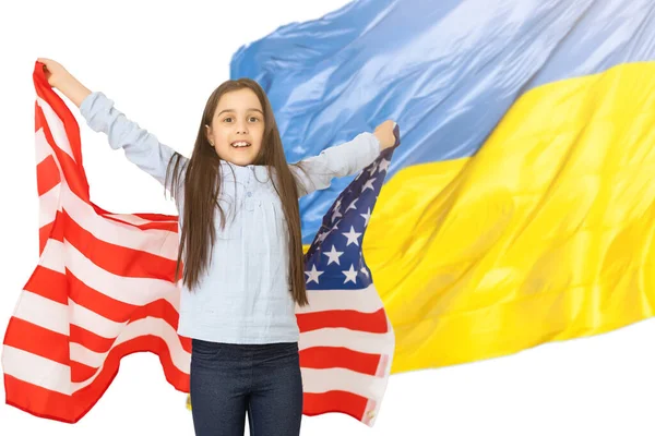 Маленька дівчинка з прапором на фоні українського прапора. — стокове фото